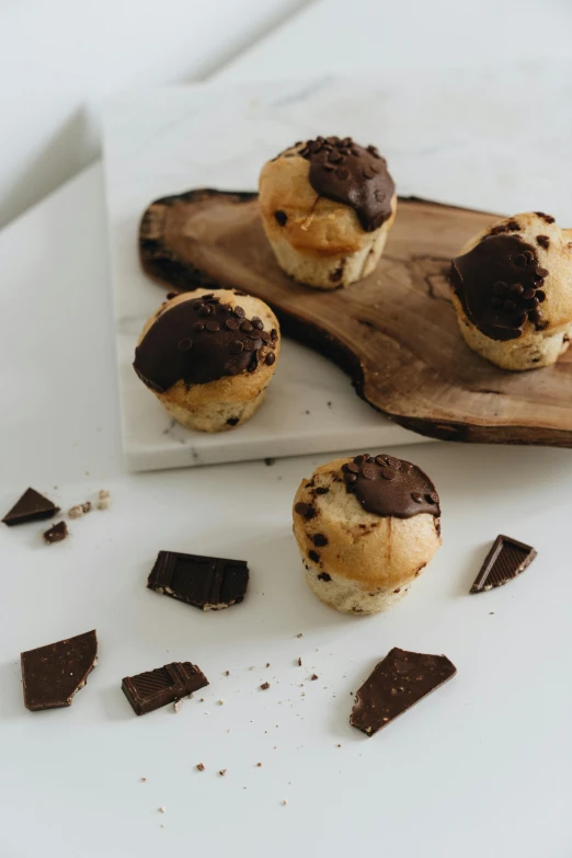 a white plate topped with cookies on top of a wooden cutting board, unsplash, baroque, chocolate frosting, bun ), thumbnail, boulders