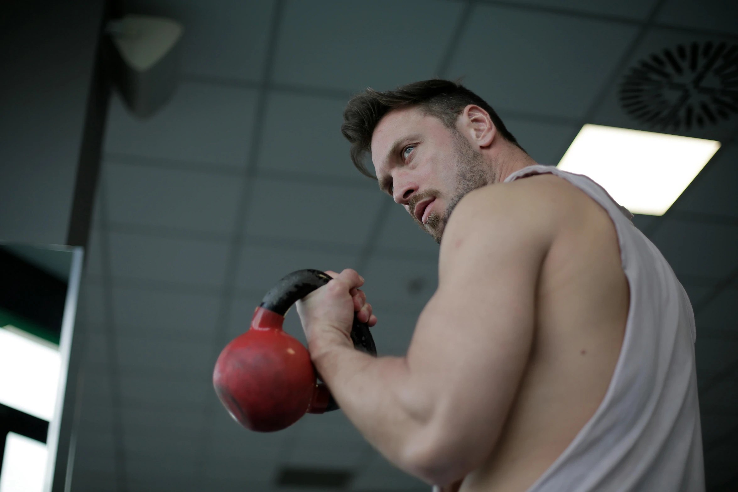 a man holding a red kettlebell in a gym, by Julian Allen, pexels contest winner, 30 year old man :: athletic, square, profile image, taken with canon 5d mk4