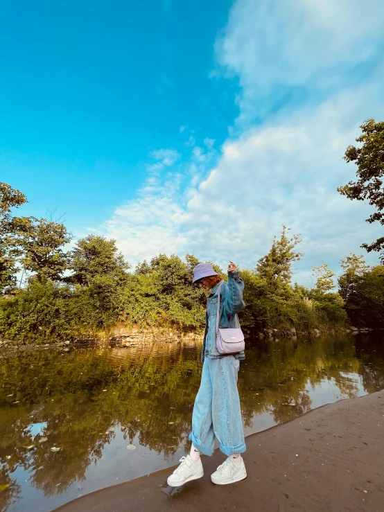 a woman standing on a beach next to a body of water, on a riverbank, profile image, sangyeob park, influencer