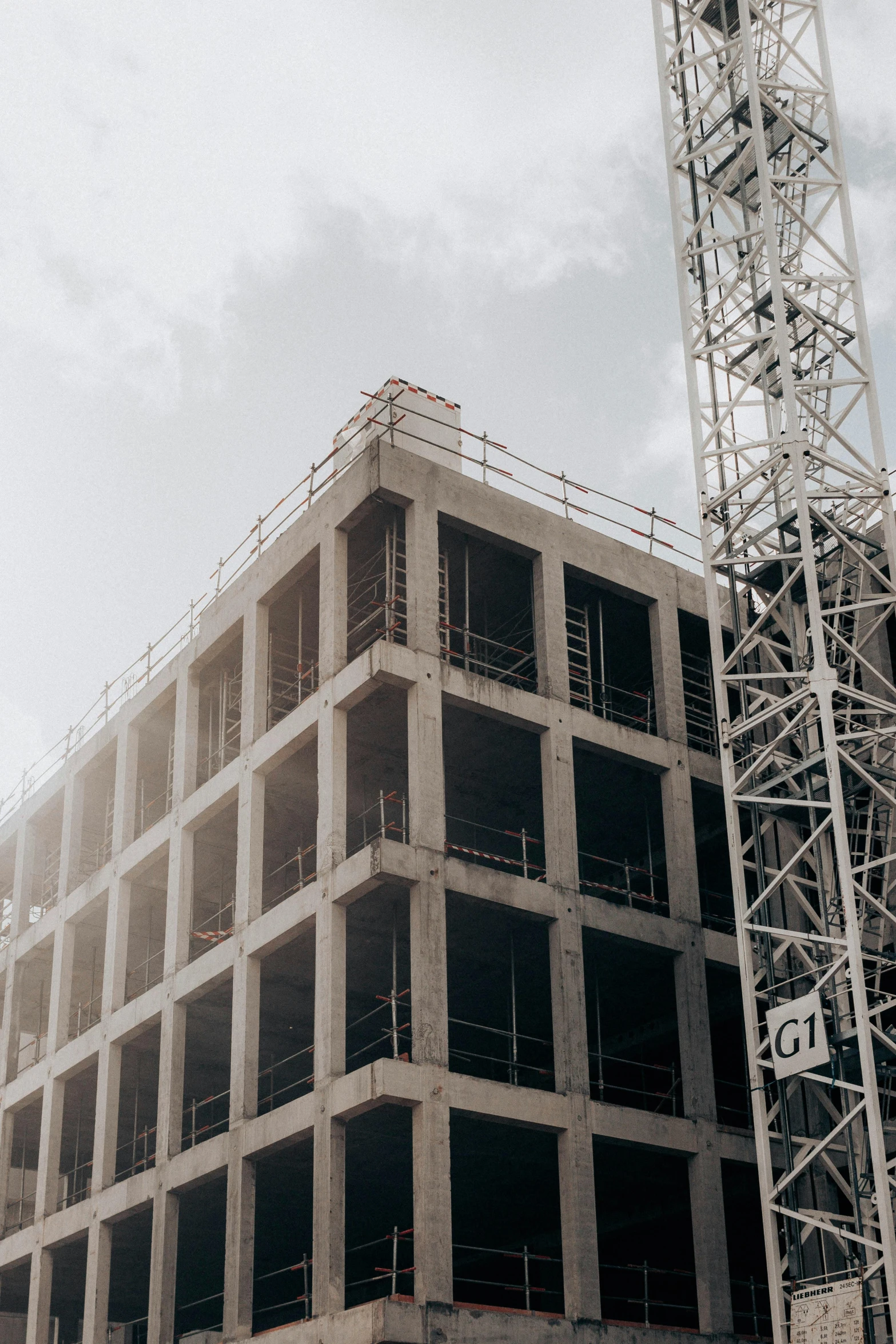 a crane standing next to a building under construction, pexels contest winner, constructivism, commercial banner, grey, shot from cinematic, inspect in inventory image