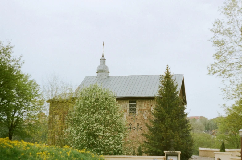 a red fire hydrant sitting in front of a building, an album cover, by Attila Meszlenyi, unsplash, renaissance, church in the wood, russian village, during spring, 2000s photo