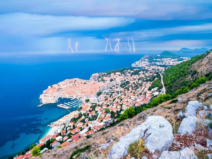 a view of a town from the top of a hill, pexels contest winner, baroque, crackling with lightning, croatian coastline, slide show, lighting bolts