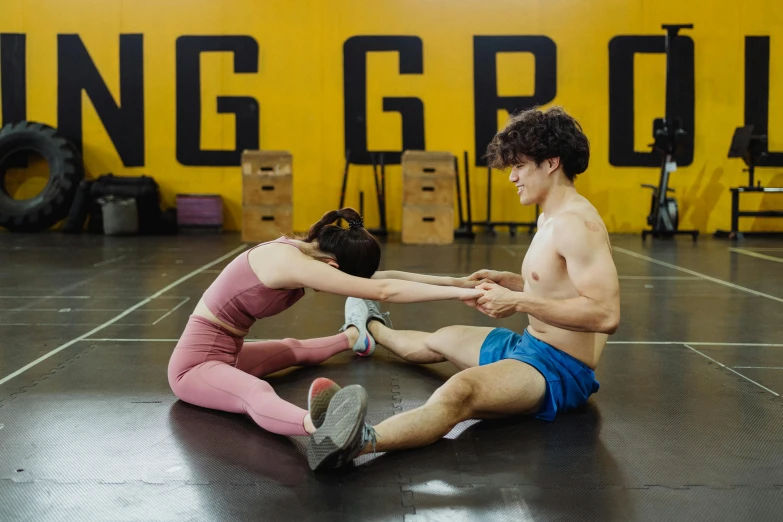 a couple of people that are sitting on the ground, by Nina Hamnett, pexels contest winner, gutai group, athletic crossfit build, declan mckenna, dynamic movie still, in the high school gym