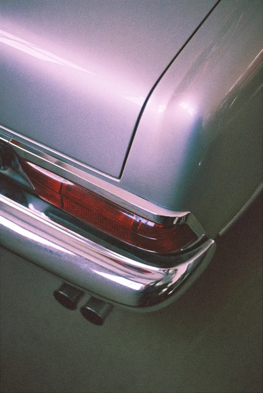 a close up of a car's tail light, an album cover, unsplash, photorealism, silver and muted colors, mercedes, purple tint, late 1 9 6 0's