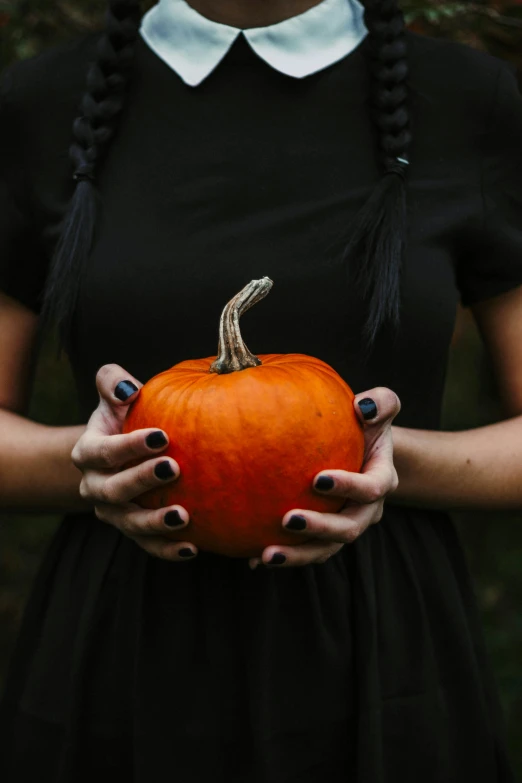 a woman in a black dress holding a pumpkin, pexels contest winner, symbolism, square, black veins, pale-skinned, 1 2 9 7