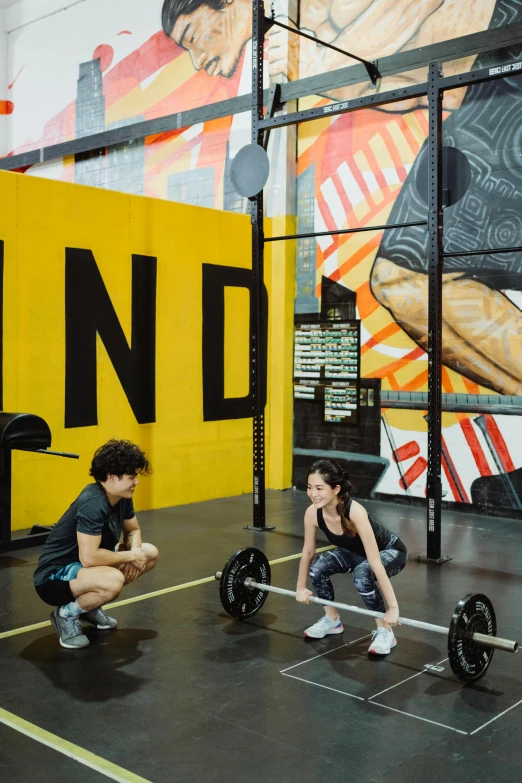 a couple of people that are in a gym, yellow and black color scheme, singapore, lifting weights, cindy avelino