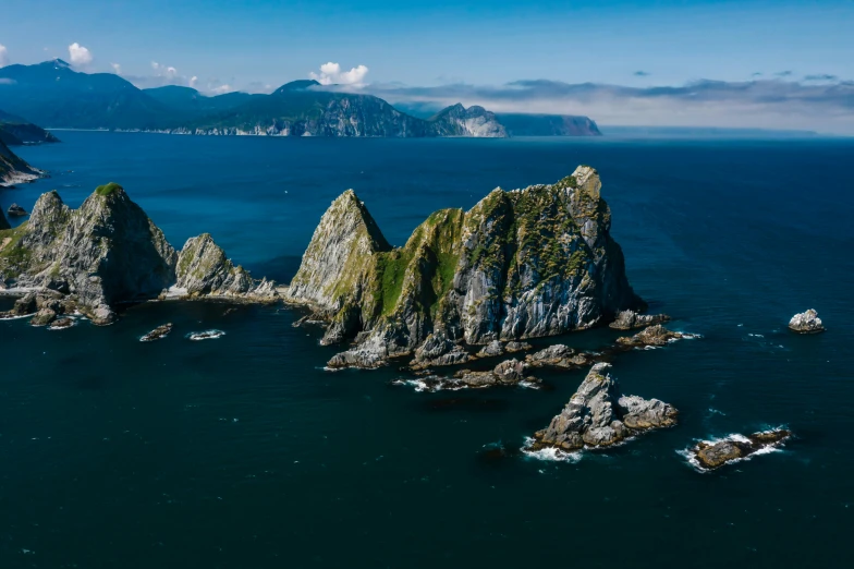 a group of rocks sitting on top of a body of water, by Doug Wildey, pexels contest winner, view from helicopter, devils horns, te pae, thumbnail