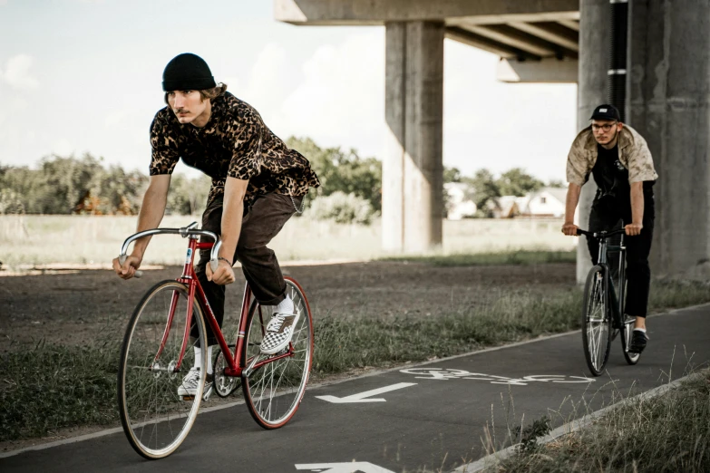 a man riding a bike next to a woman on a bike, pexels contest winner, aboriginal australian hipster, sports clothing, full lenght, college