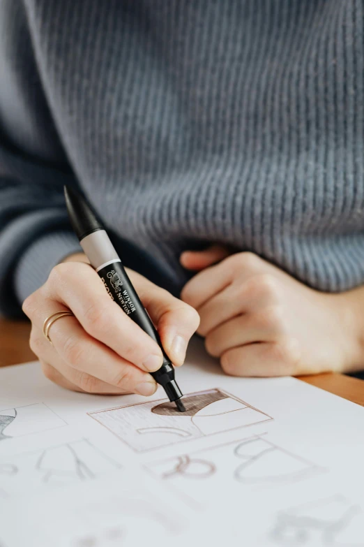 a person writing on a piece of paper with a pen, a drawing, black ink & copic markers, iconic design, subtle detailing, style lettering