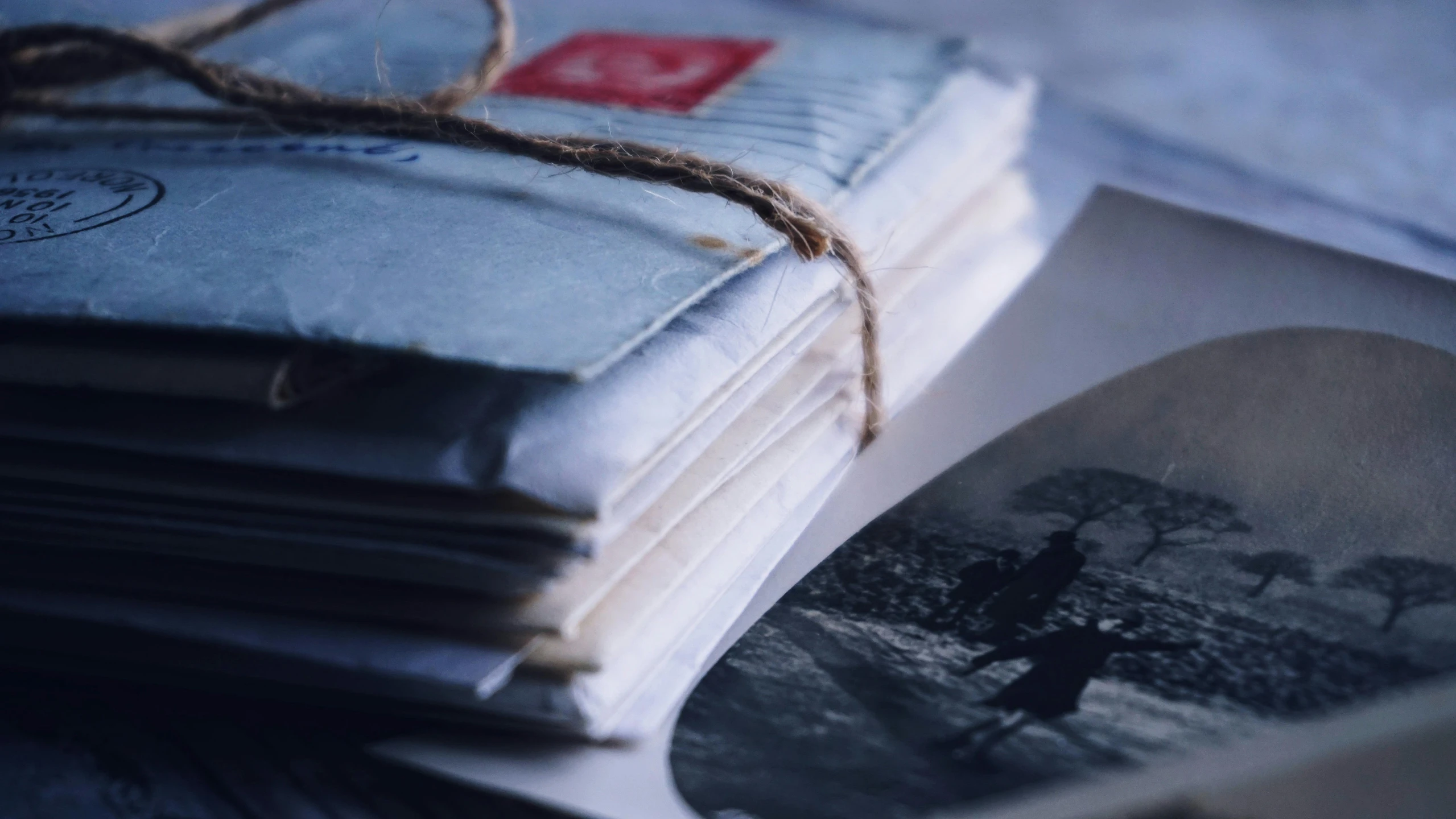 a stack of old photos sitting on top of a table, by Daniel Lieske, pexels contest winner, mail art, close - up profile, evening light, delivering mail, an ultra realistic