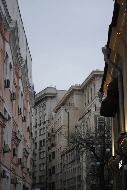 a city street filled with lots of tall buildings, inspired by Mihály Munkácsy, art nouveau, the place is just really small, neo classical architecture, down-town, exterior