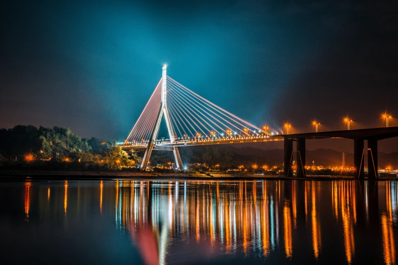 a bridge over a body of water at night, by Adam Marczyński, pexels contest winner, hurufiyya, guwahati, fully symmetrical, details and vivid colors, beautiful sunny day