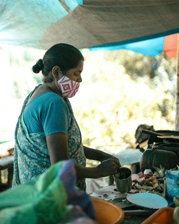 a woman wearing a face mask preparing food, by Hannah Tompkins, sri lanka, coffee, no cropping, shady