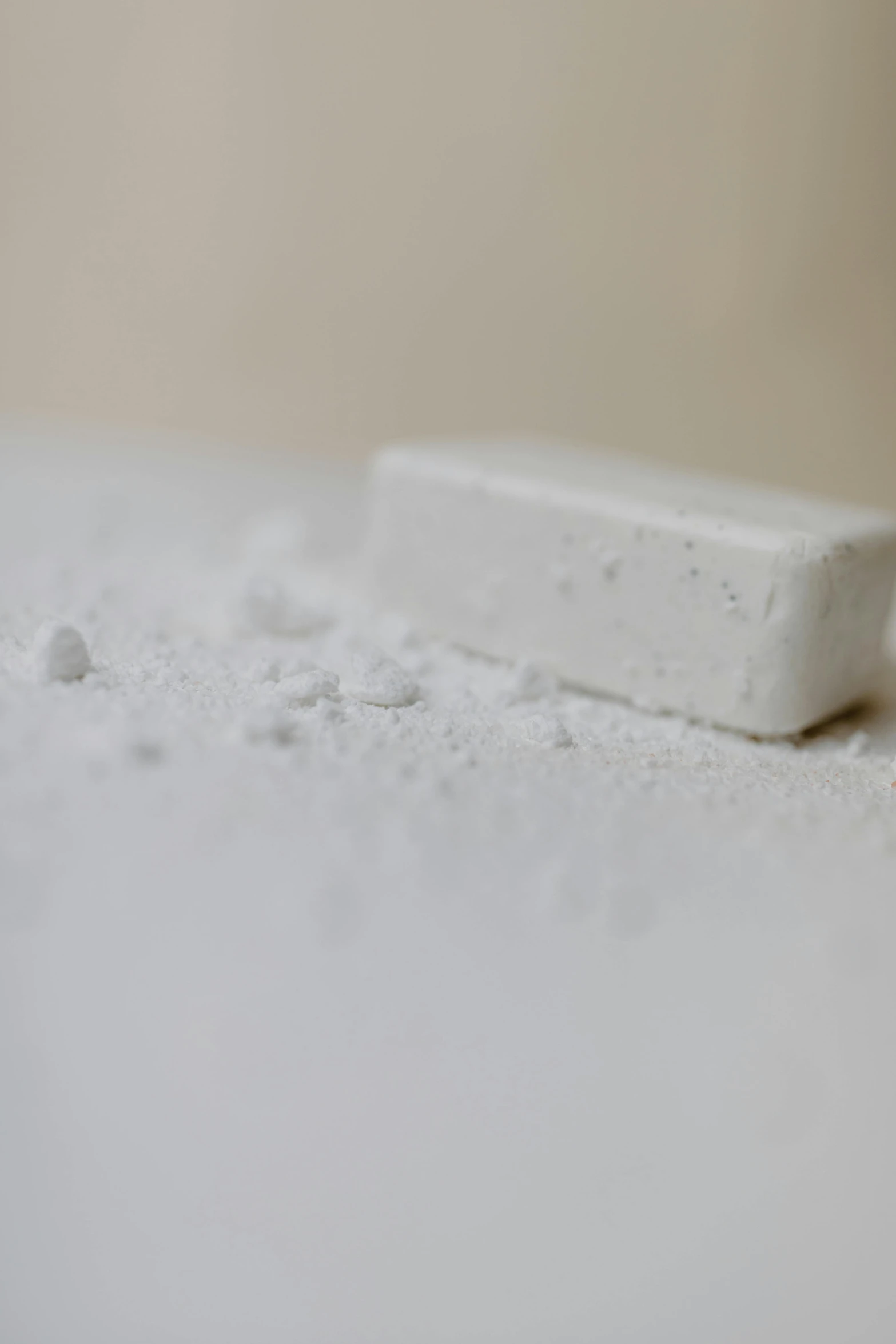 a toothbrush sitting on top of a white table, inspired by Rachel Whiteread, unsplash, powdered sugar, white powder bricks, ignant, close up angle