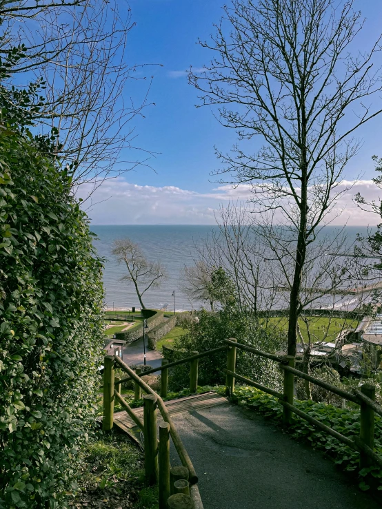 a view of the ocean from the top of a hill, by Kev Walker, small path up to door, park on a bright sunny day, thumbnail, outdoor staircase