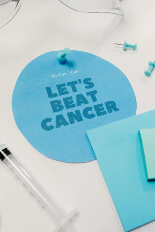 a blue sticker with the words let's beat cancer on it, an album cover, pexels contest winner, pen and paper, poster template on canva, 240p, detail shot