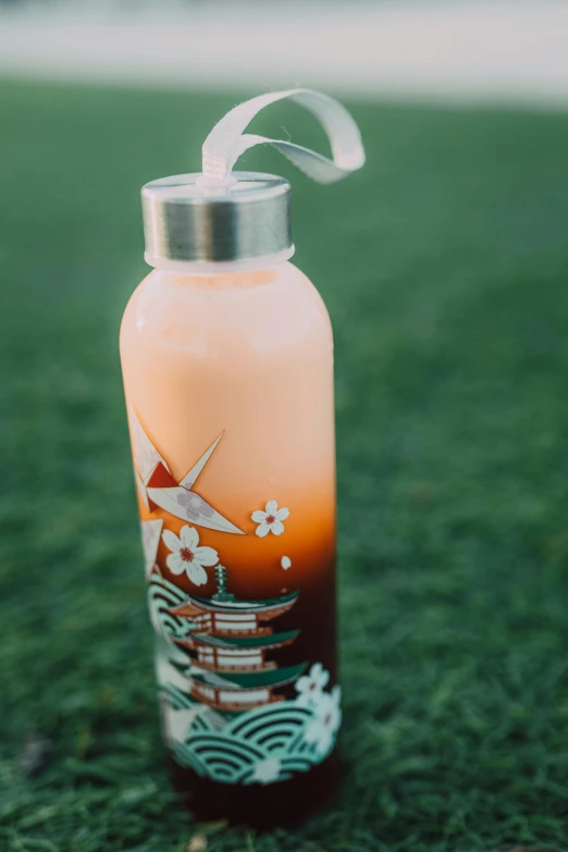 a water bottle sitting on top of a lush green field, inspired by Kanō Tan'yū, sōsaku hanga, sunset glow, close-up product photo, geisha, glass paint