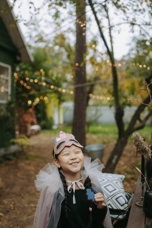 a couple of little girls standing next to each other, pexels contest winner, wearing a crown of vines, standing outside a house, girl under lantern, smiling laughing