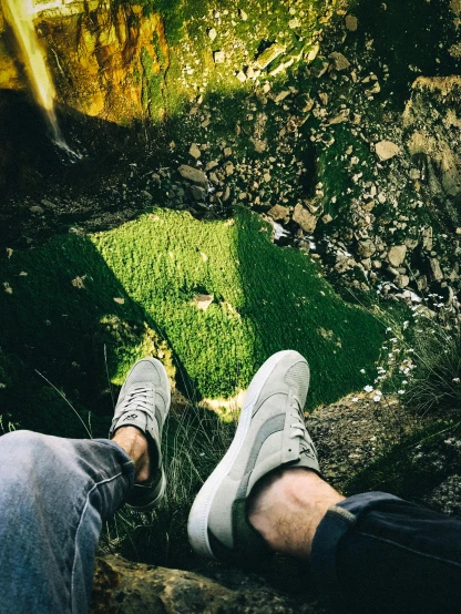 a couple of people that are sitting on some rocks, acid-green sneakers, shot with iphone 1 0, nature overgrowth, down there