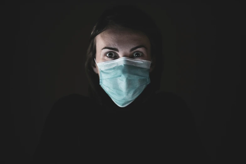 a woman wearing a face mask in the dark, a picture, pexels, happening, shocked look, healthcare worker, avatar image, looking into camera