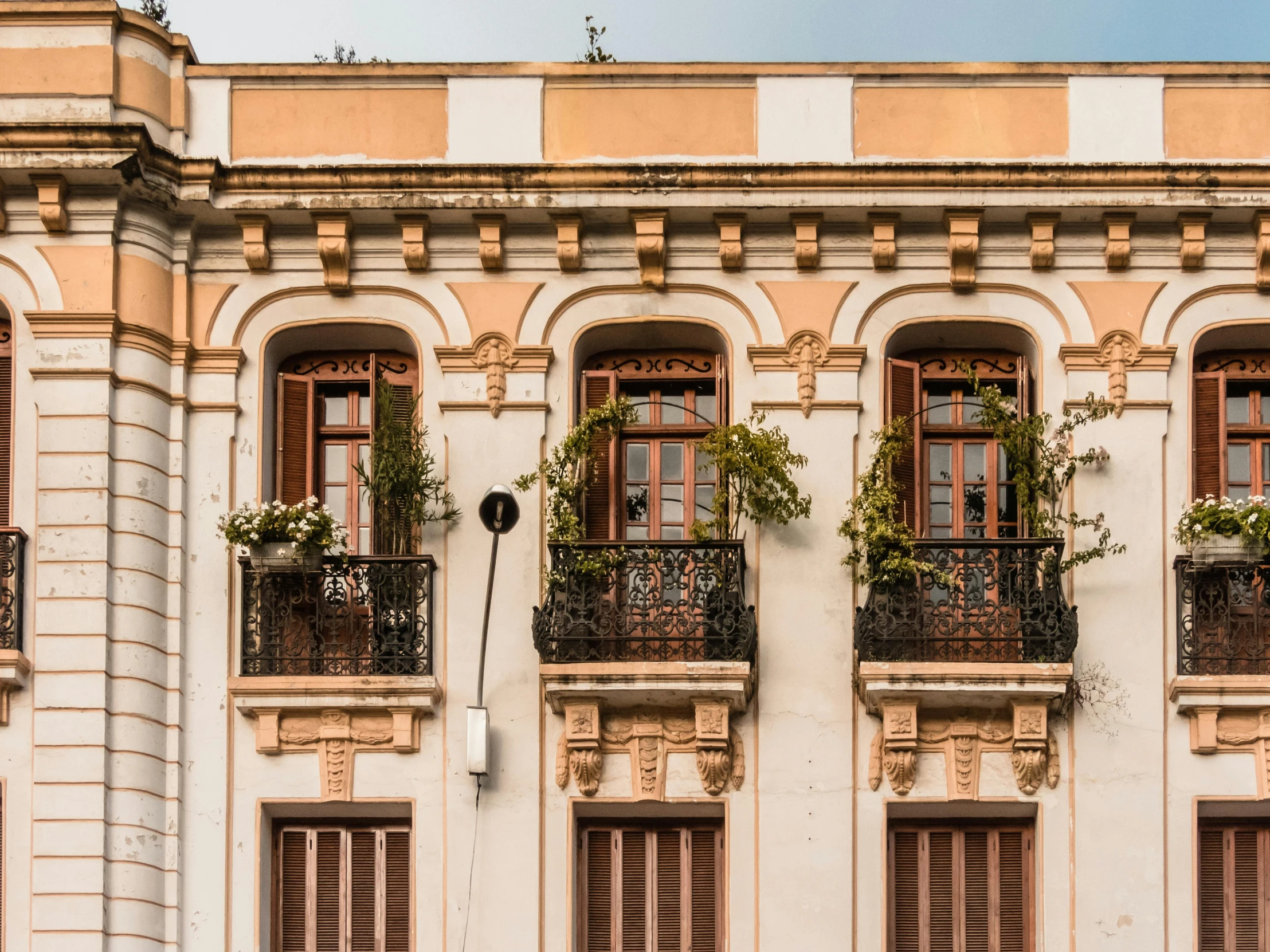 a building with lots of windows and balconies, inspired by Lajos Berán, pexels contest winner, neoclassicism, tlaquepaque, exterior view, architectural digest, peruvian looking