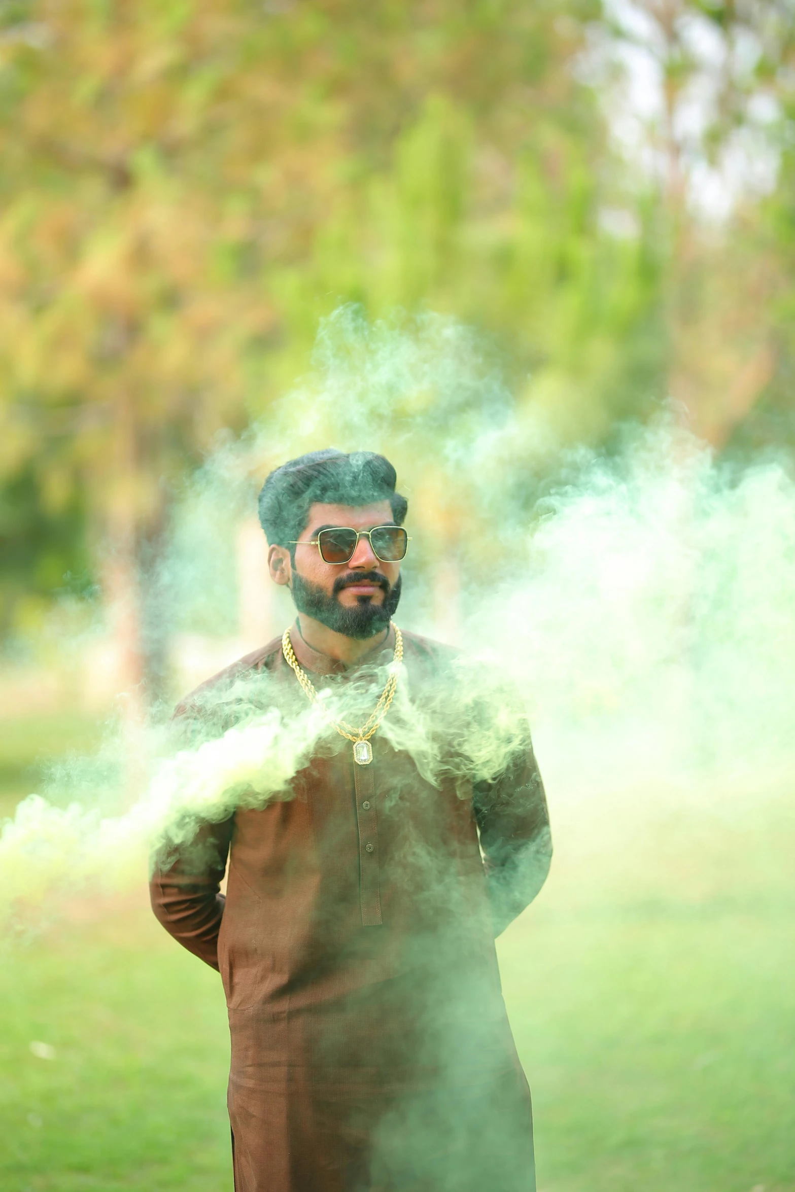 a man standing on top of a lush green field, thick pigmented smoke, at college, celebration, profile pic