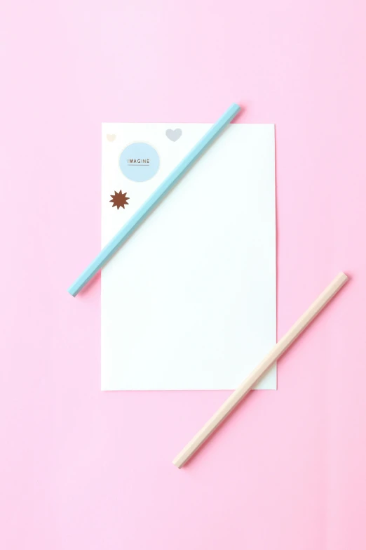 two pencils and a piece of paper on a pink background, holo sticker, pale blue, full product shot, instagram story