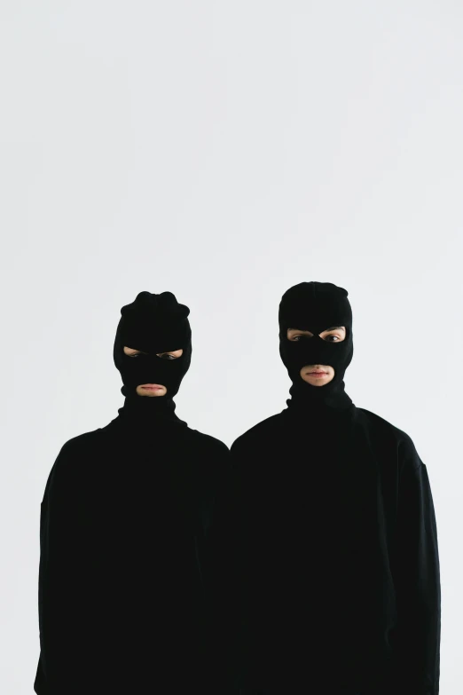 two people dressed in black standing next to each other, an album cover, unsplash, antipodeans, balaclava, adult pair of twins, joon ahn, robbery