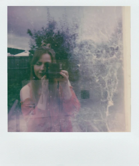 a woman taking a picture with a camera, a polaroid photo, inspired by Elsa Bleda, unsplash, romanticism, pale red, distorted photo, scanned in, ellie bamber