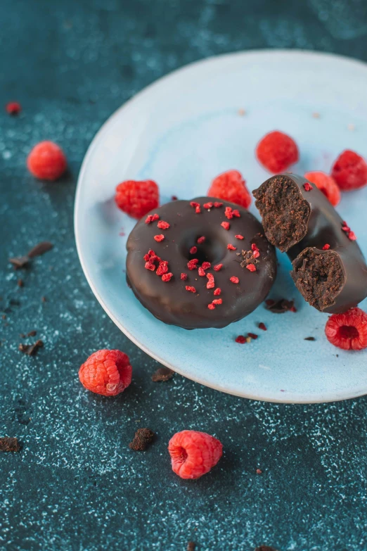 two chocolate donuts on a plate with raspberries, by Julia Pishtar, romanticism, hero shot, red - black, 1x, moroccan