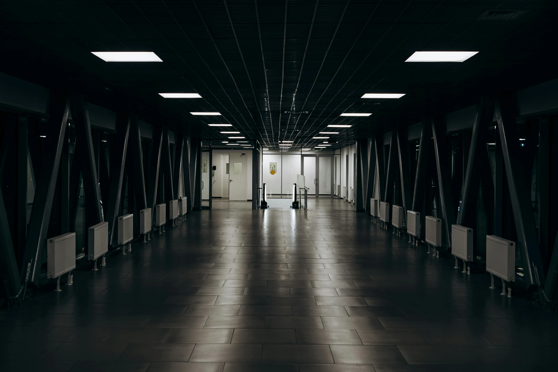 a black and white photo of a long hallway, by Adam Marczyński, pexels contest winner, fluorescent lights, airport, black floor, thumbnail