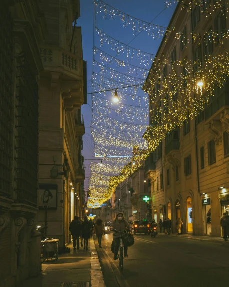 a group of people walking down a street next to tall buildings, unsplash contest winner, renaissance, string lights, roma, decorations, lgbtq