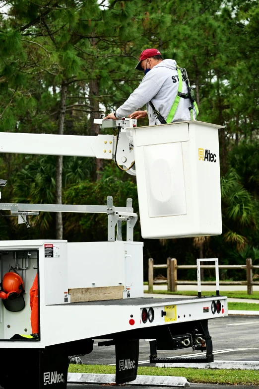 a man that is standing in the back of a truck, white panels, climbing, utility, florida man