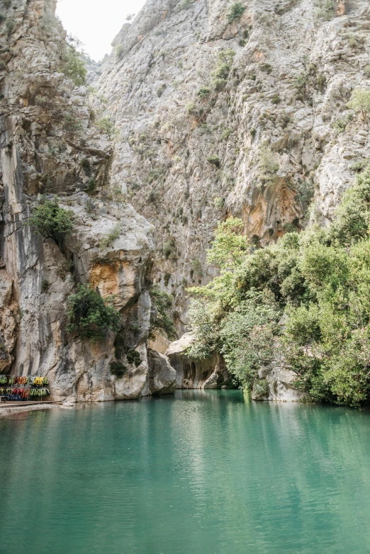 a body of water surrounded by rocks and trees, hurufiyya, turkey, steep cliffs, null, multicoloured
