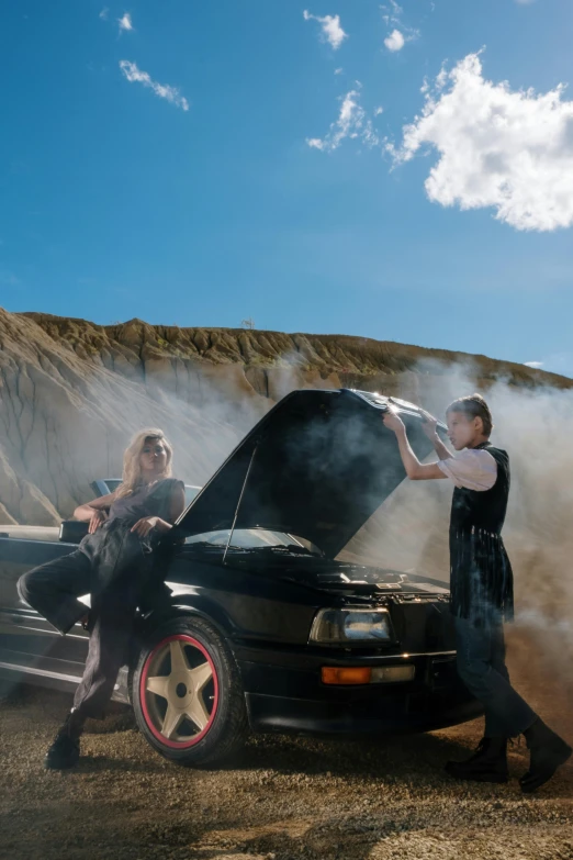 a couple of people standing next to a car, pexels contest winner, auto-destructive art, liquid smoke twisting, badlands, sassy pose, mechanic