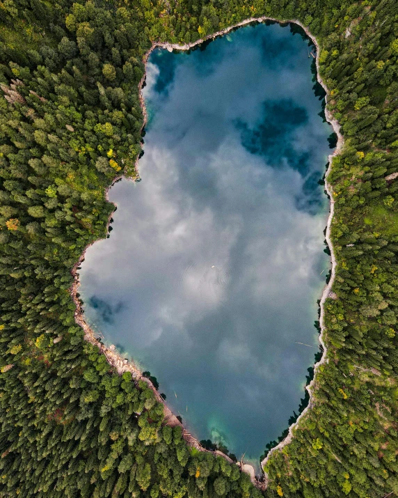 an aerial view of a lake surrounded by trees, by Sebastian Spreng, unsplash contest winner, thumbnail, shaped picture, clouds around, tourist photo