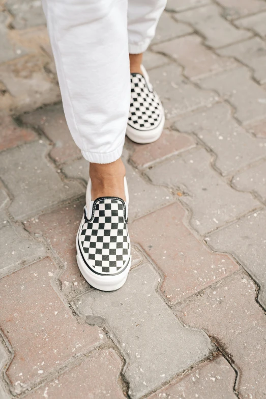 a person wearing white pants and black and white checkered shoes, zoomed in, van, vine, detailed product shot