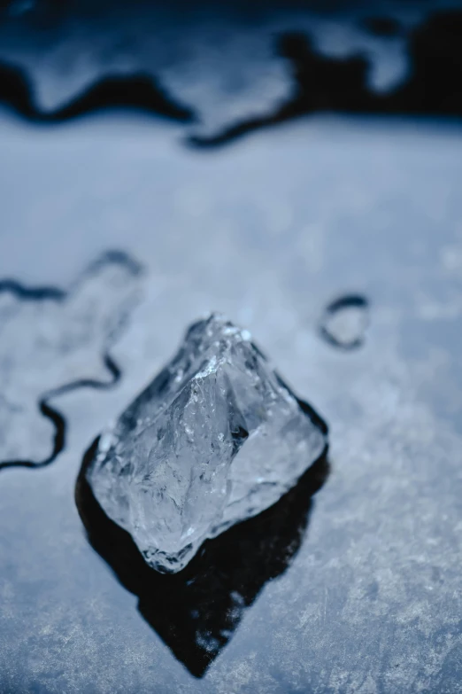 a piece of ice sitting on top of a puddle of water, unsplash, 8k resolution”, made of diamond, slate, high quality”