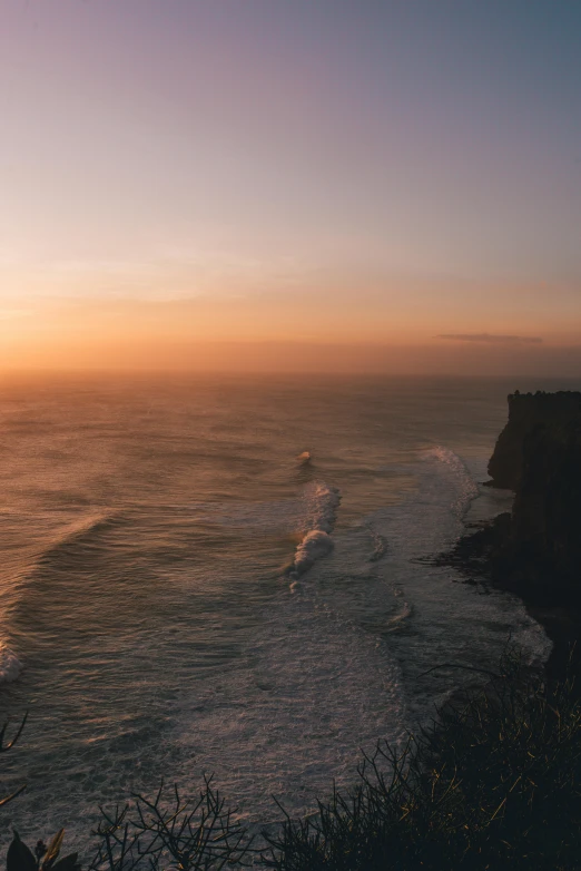 a large body of water next to a cliff, by Daniel Seghers, pexels contest winner, romanticism, in a sunset haze, flying over the ocean, te pae, 4 k cinematic panoramic view