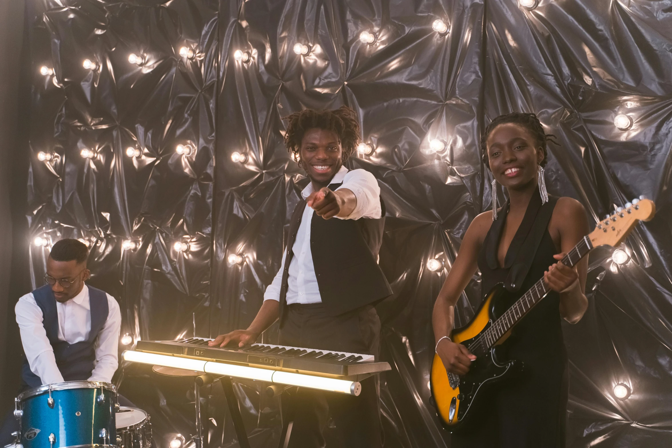 a group of people that are standing in front of a keyboard, maria borges, performing a music video, band, glimmering