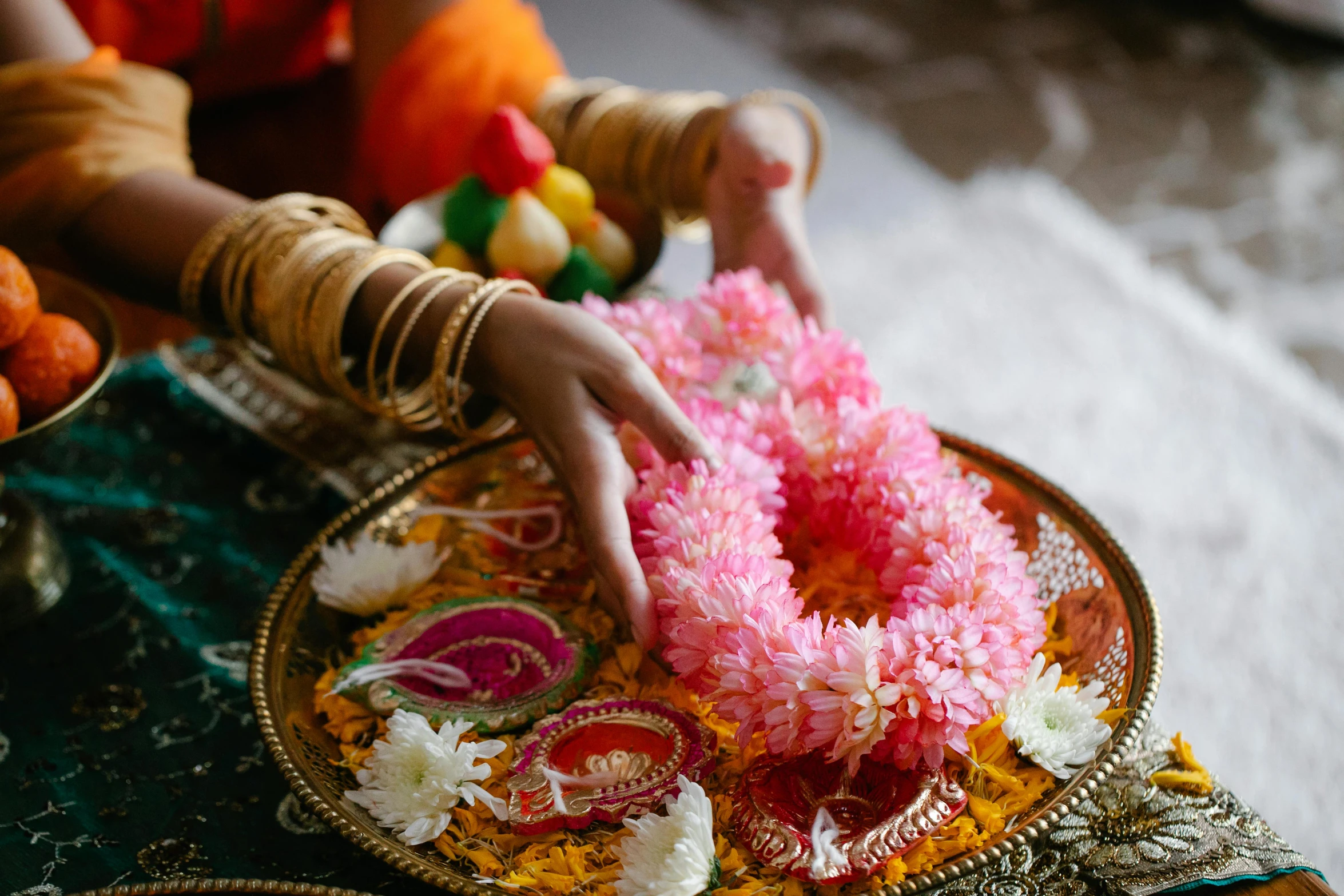 a close up of a person putting flowers on a plate, hurufiyya, hindu ornaments, pink and orange, posing, floating bouquets