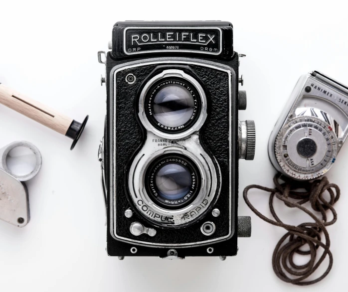 a couple of old cameras sitting next to each other, a black and white photo, by Andrée Ruellan, pexels contest winner, photorealism, rolleiflex tlr, set against a white background, flatlay, vintage color
