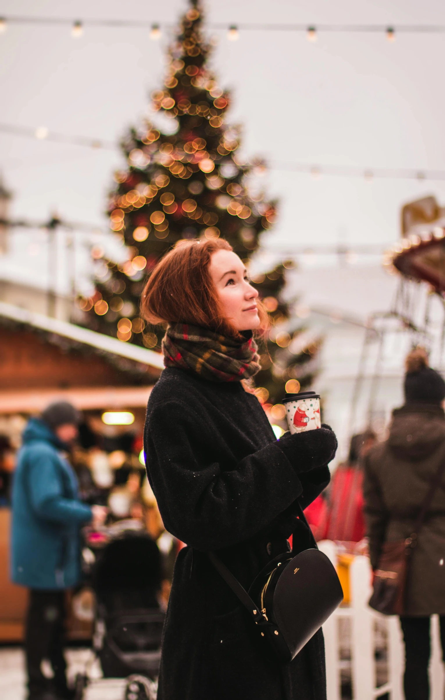 a woman standing in front of a christmas tree, pexels contest winner, happening, al fresco, avatar image, market, with a cup of hot chocolate