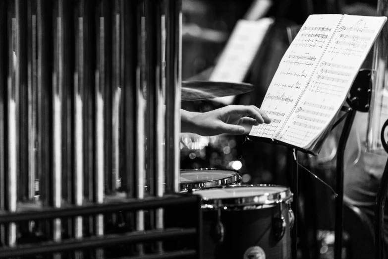 a close up of a person holding a sheet of music, by Patrick Pietropoli, band playing instruments, 15081959 21121991 01012000 4k, playing drums, monochrome