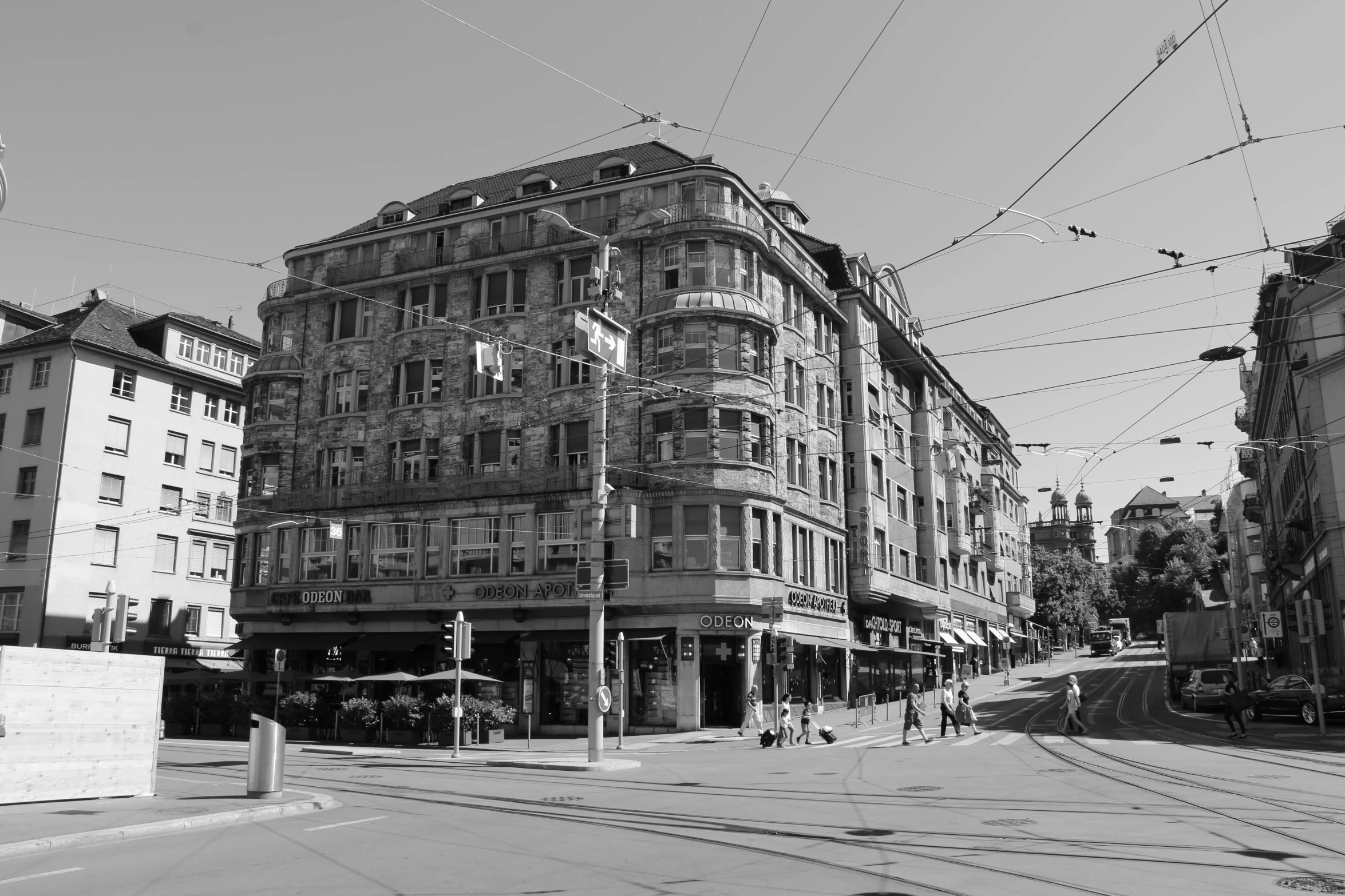 a black and white photo of a city street, a black and white photo, inspired by Karl Stauffer-Bern, flickr, art nouveau, big poor building, near the beach, intersection, summer day