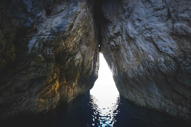 a cave in the middle of a body of water, doorway, capri coast, light dark, head straight down