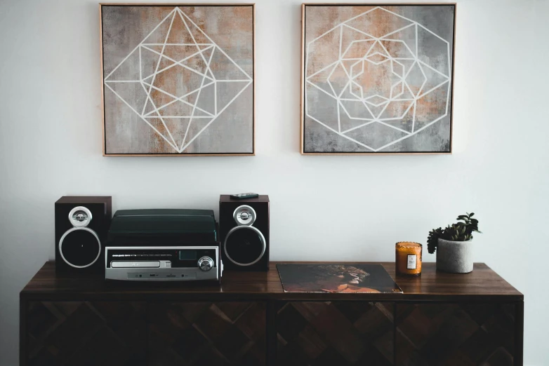 a stereo system sitting on top of a wooden table, a minimalist painting, inspired by Lubin Baugin, trending on unsplash, geometric abstract art, 144x144 canvas, geometric tattoos, epic diptych, sirius a and sirius b