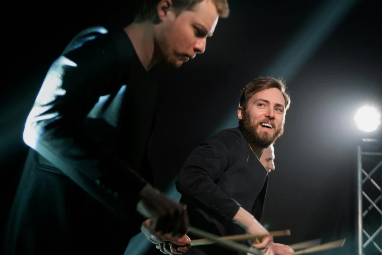 two men are playing drums on a stage, an album cover, inspired by Hallsteinn Sigurðsson, pexels contest winner, looking to his side, vantablack, threyda, portrait image