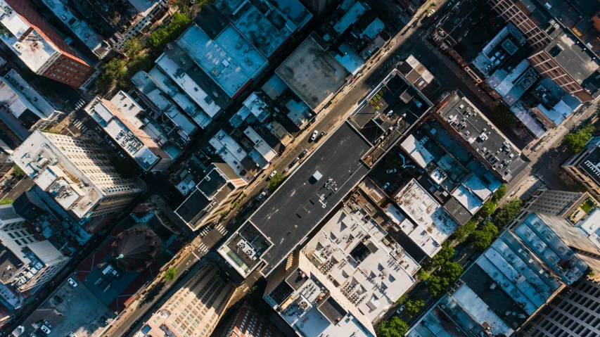 an aerial view of a city with lots of tall buildings, by Carey Morris, pexels contest winner, new york alleyway, sharp roofs, top view of convertible, unsplash 4k