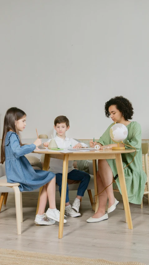 a woman sitting at a table with two children, pexels, furniture, high quality photo, educational supplies, pastel'